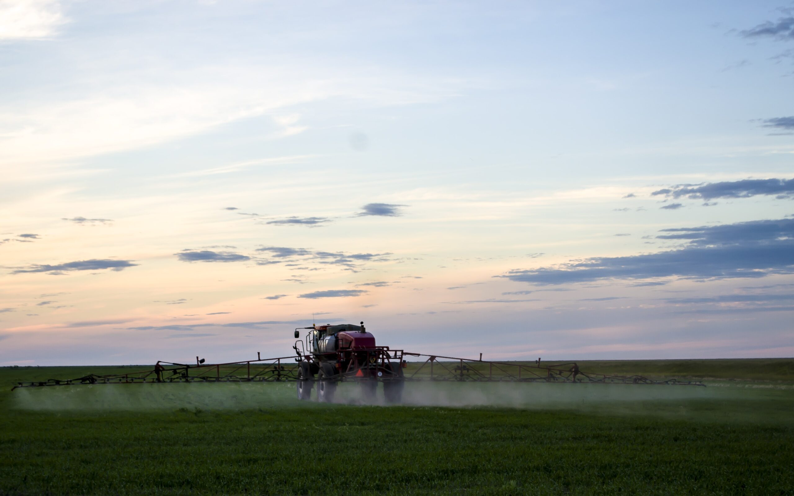 photo-of-wheat-field-spraying-tractor-with-agrochemical-or-agrochemical-preparations-over-youn-min